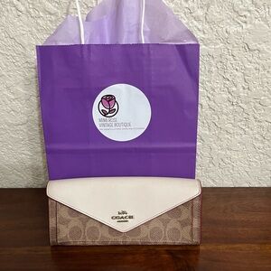 Coach monogram wallet with red leather lining. Good condition.